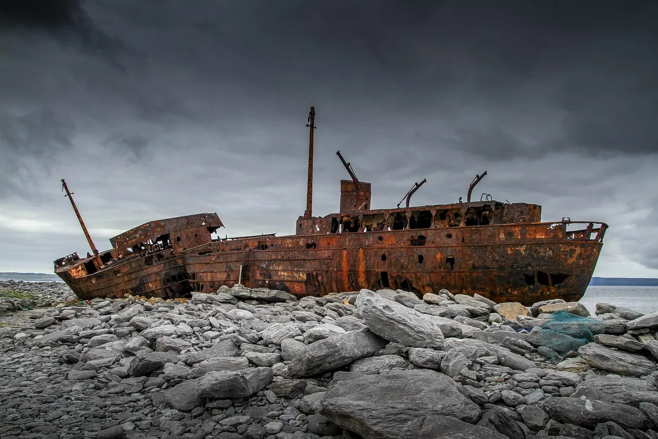Épave de cargo échoué sur la côte rocheuse — vestige industriel qui donne son nom au spot Boilers