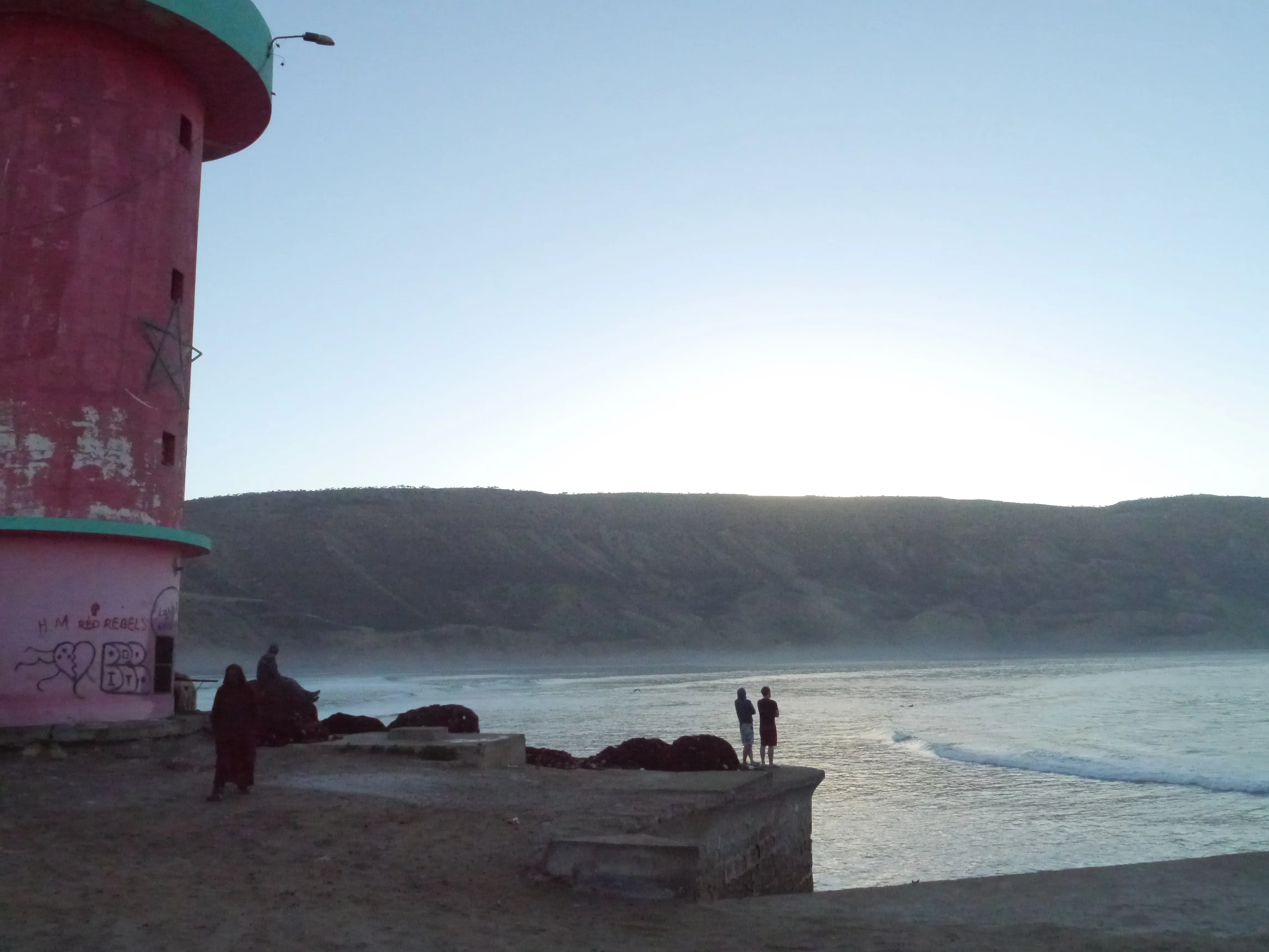 Wide view of Imsouane's Cathedral Bay with surfers lined up on the long right-hand wall