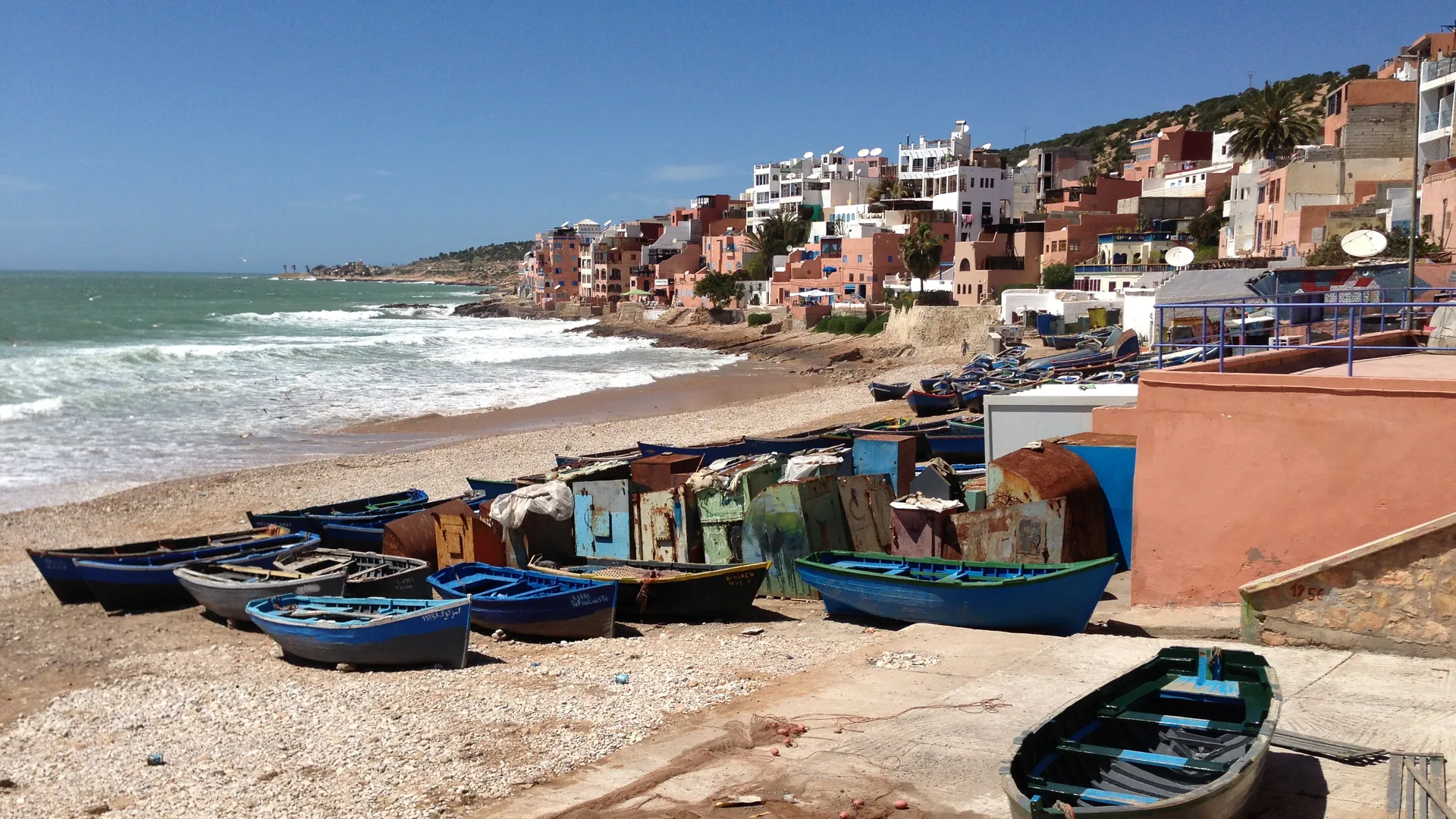 Blue fishing boats at Taghazout — the historic village remains a working port, 5 km north of the Taghazout Bay zone where the Hyatt Regency sits