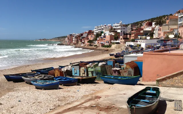 Blue fishing boats at Taghazout — the historic village remains a working port, 5 km north of the Taghazout Bay zone where the Hyatt Regency sits