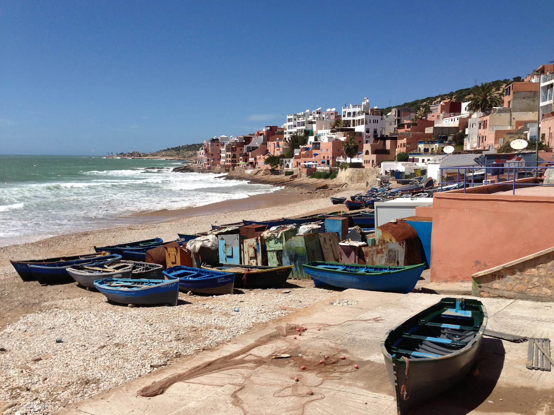 Barques de pêche bleues sur la plage de Taghazout — le village historique au bout de la P8 depuis Agadir