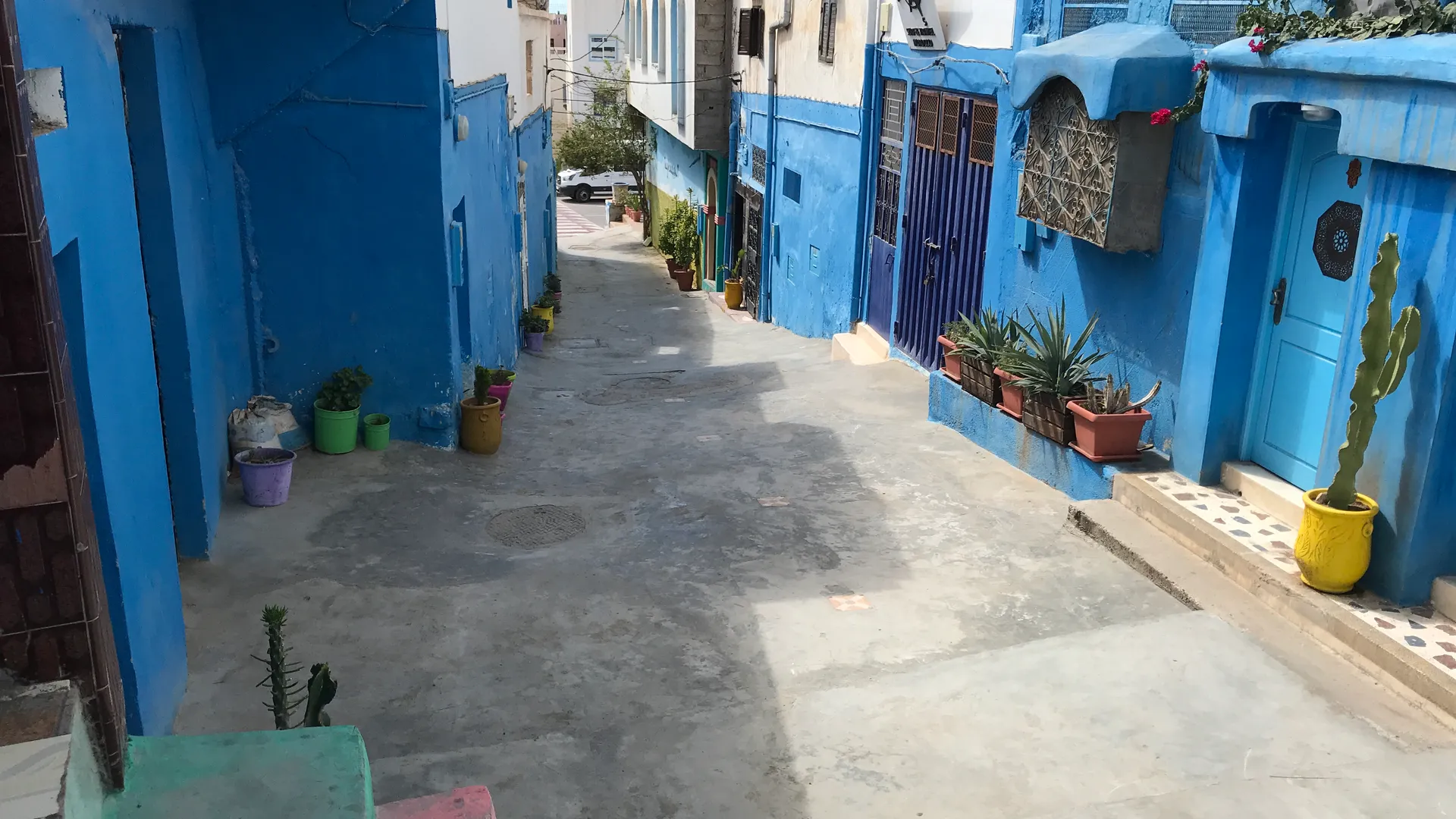 Traditional Taghazout lane lined with blue-and-white houses — the local reference behind the contemporary architecture of the Fairmont Taghazout Bay