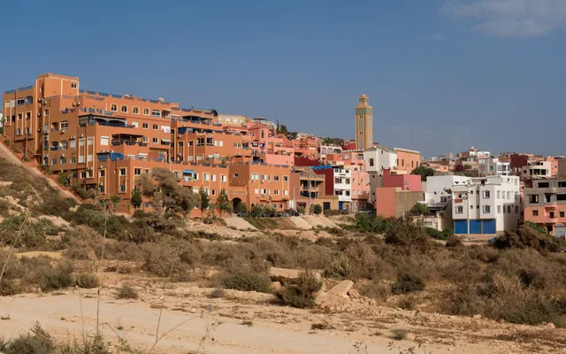Tamraght — coloured houses stepped up the hillside above the Atlantic, the village mosque at the centre